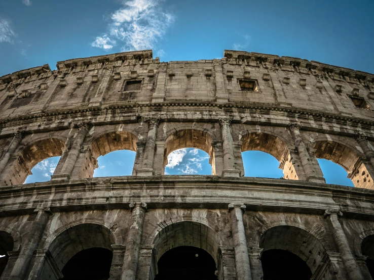 an roman colossion sits under a bright blue sky