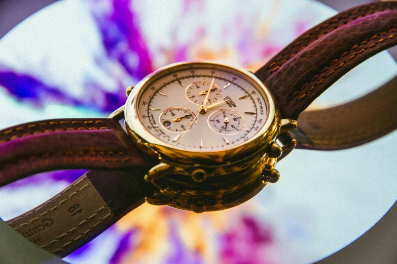 the large wrist watch is on top of the brown strap