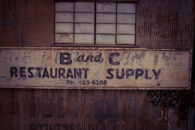 an old rusty sign on a building that says blind cram restaurant supply