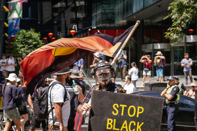 people walking down a city street with signs and flags