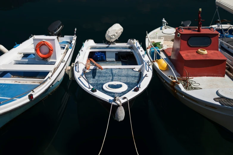 three boats are tied up to each other on the water