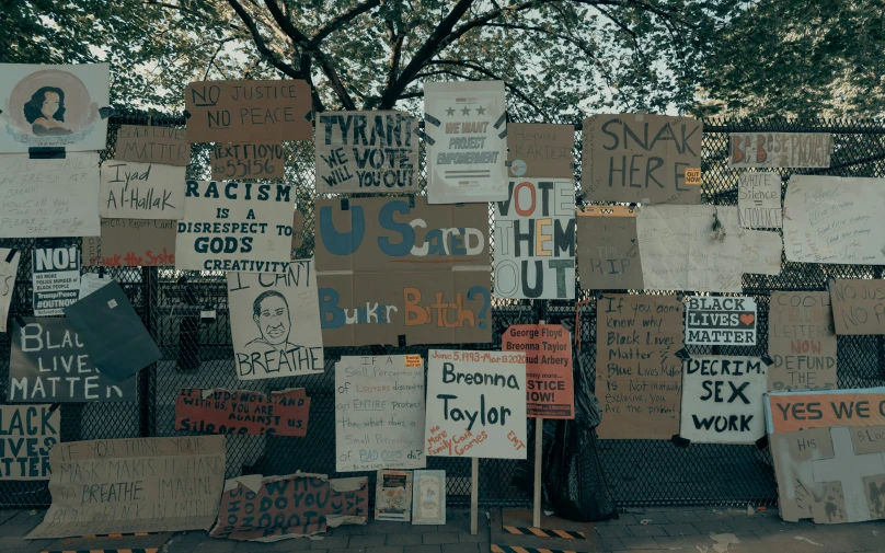 many signs that are stuck on the fence