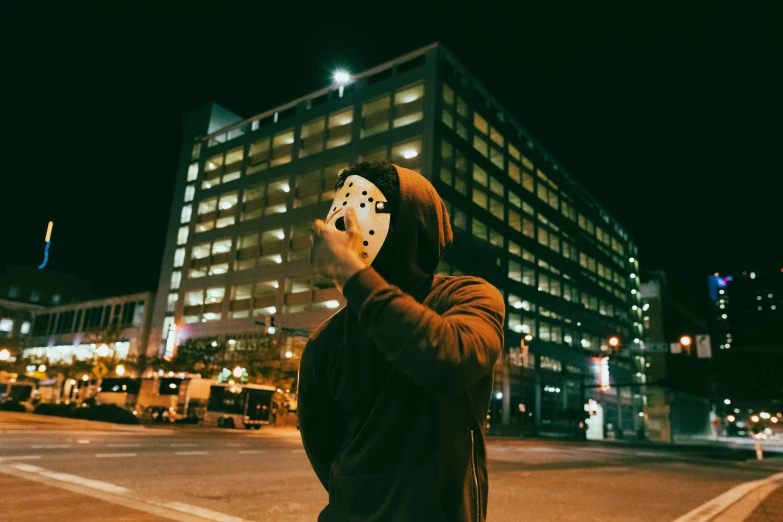 a man wearing a mask and holding a knife standing on a city street