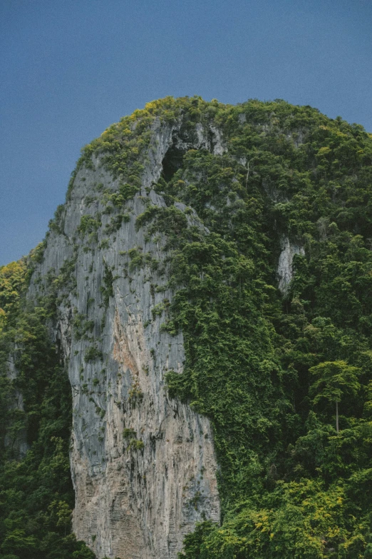 a sail boat on the water near a cliff