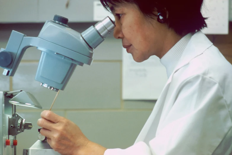 the woman looks at the microscope in her laboratory