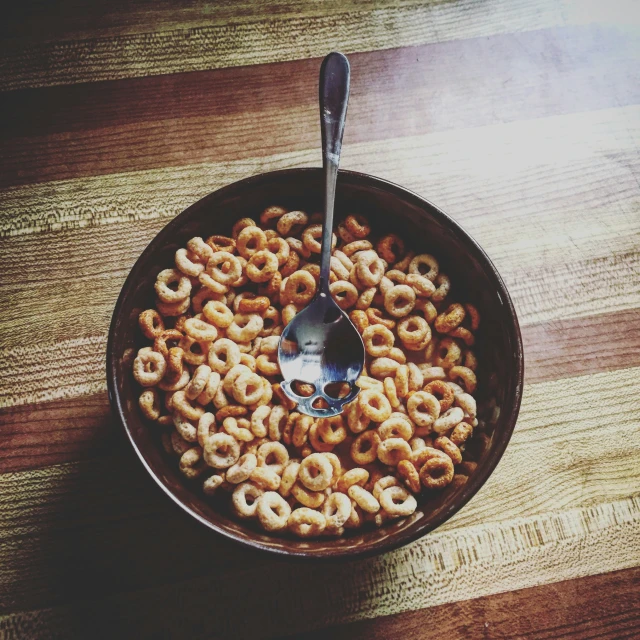 a bowl with a spoon in it on top of a table