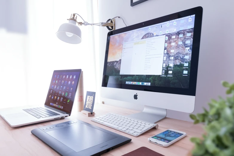 a desk with two laptops and two monitors