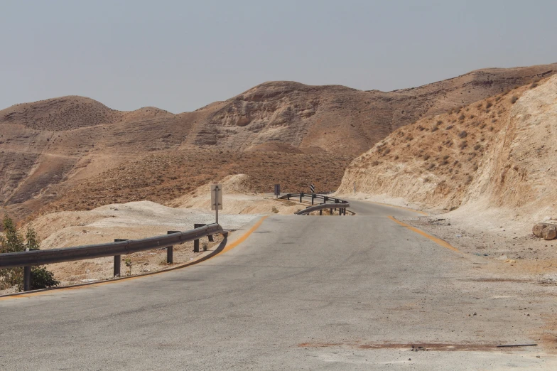 three wooden benches are placed at the edge of the roadway