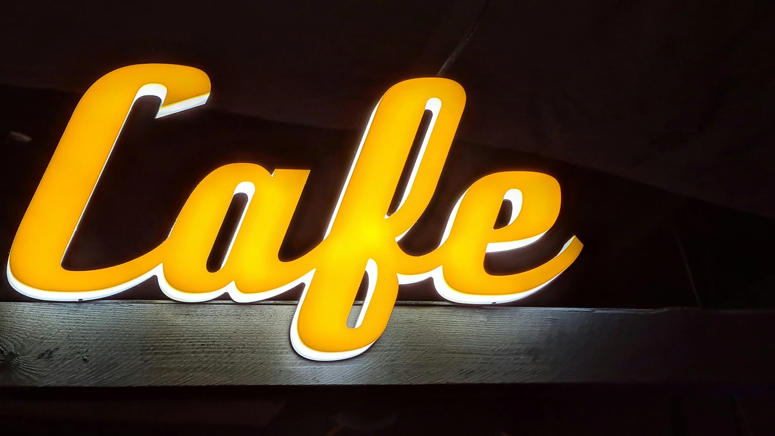 a sign that reads cafe in illuminated up