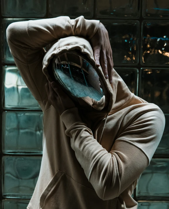 a person wearing a hooded jacket with their hands under their head