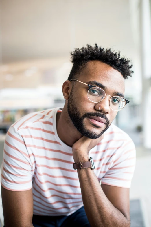 a man in glasses sitting on top of a table