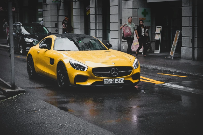 a yellow mercedes benz in the rain