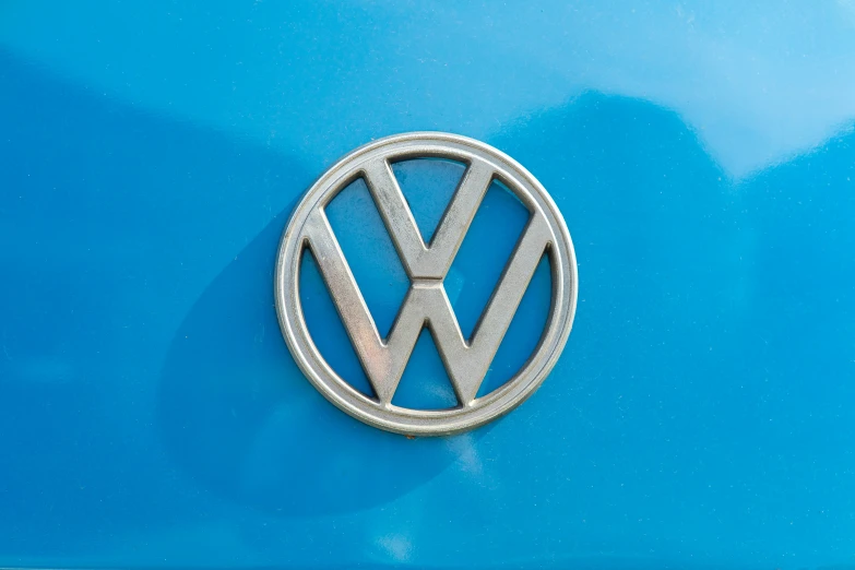 a close up of a vw emblem on a blue car