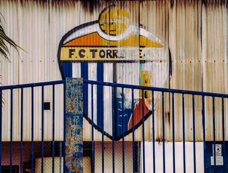 a fence is painted with a blue and yellow striped stripe