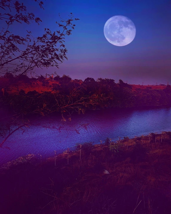 a full moon is reflected in a lake