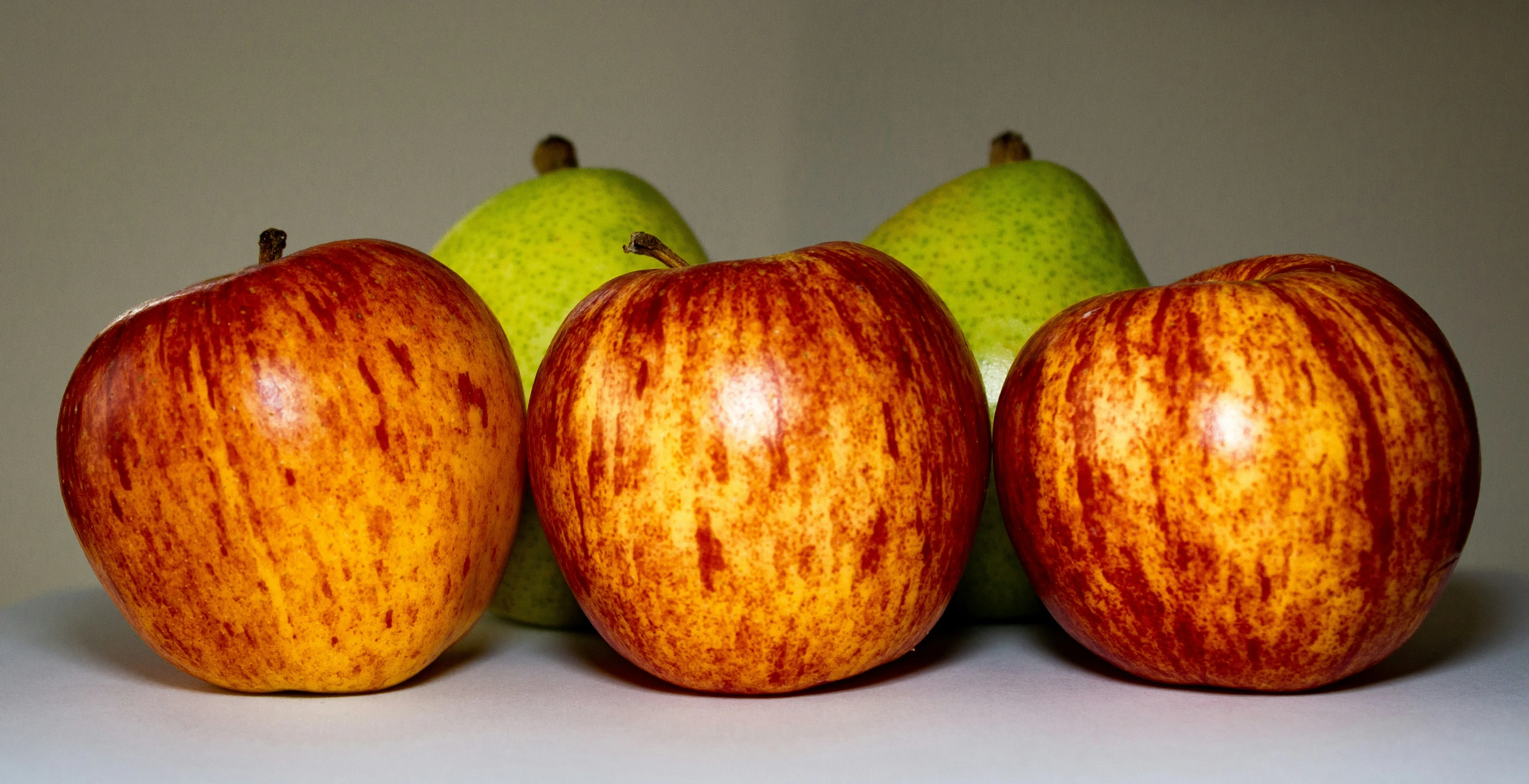 three apples are next to three green pears