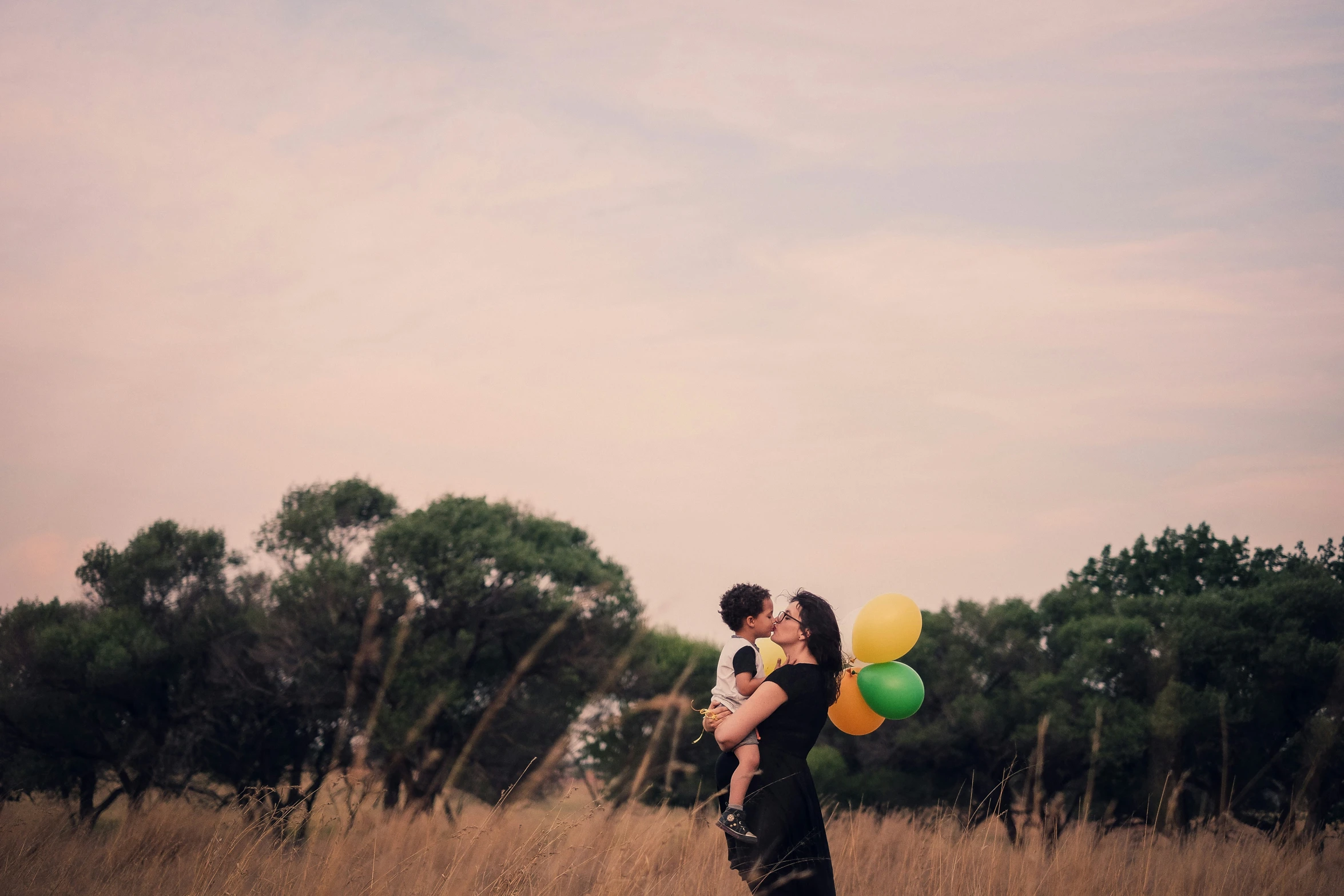 a man and woman holding bunch of balloons