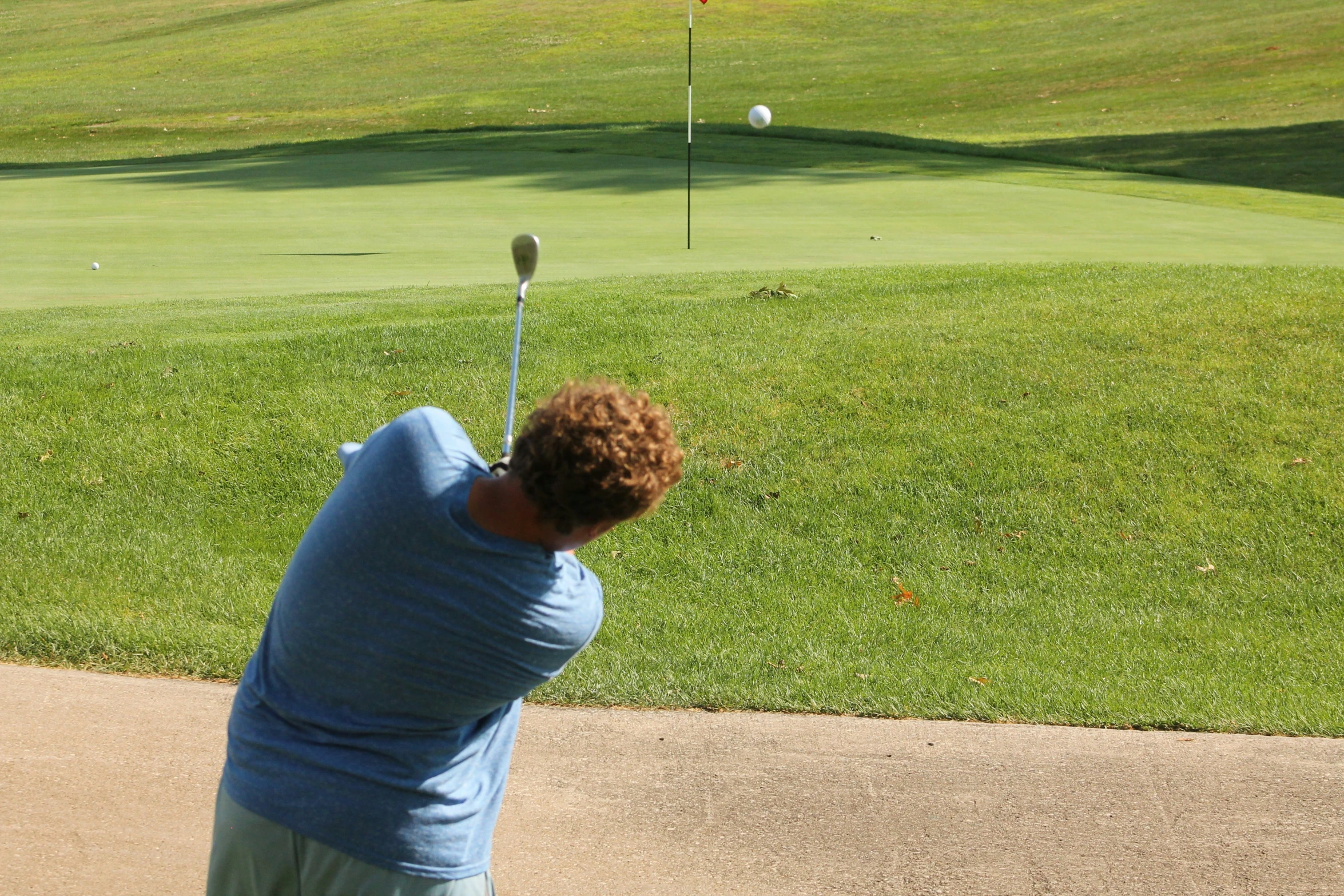 a man swinging his golf club at a ball