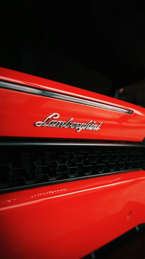 the front grill of a red mustang with a small bird above it