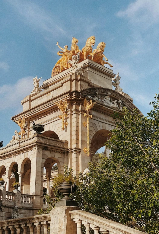 the front entrance to an ornate building with statues on the top