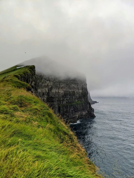 a lone bench on the side of a green hill