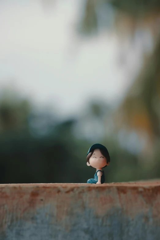 a small figurine wearing a baseball cap on top of a wooden beam