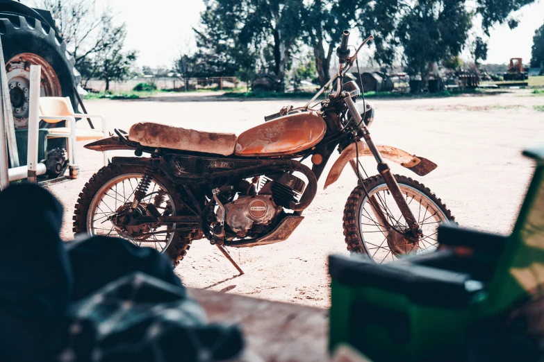 an old motorcycle sits in front of a vintage vehicle