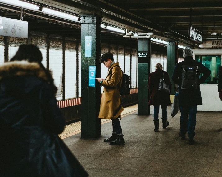 there are people walking near a subway train stop