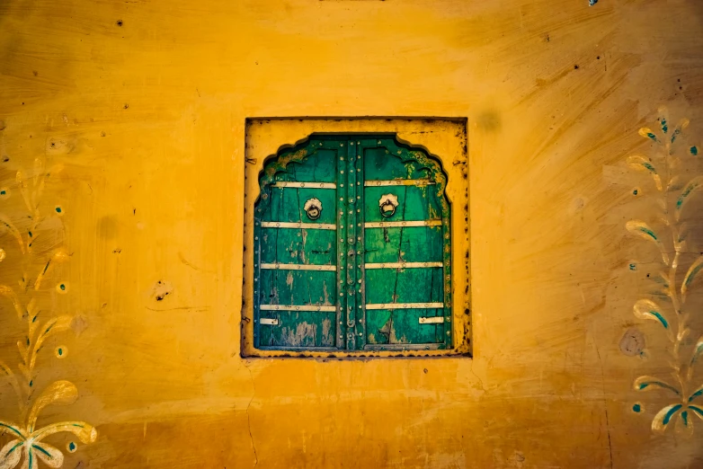 a green door sitting above a yellow wall