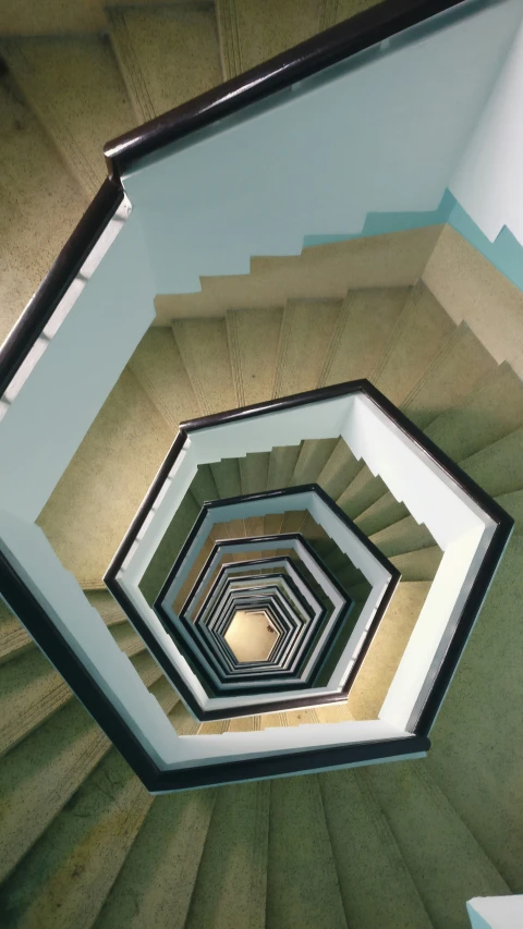 a spiral staircase with green and brown stairs