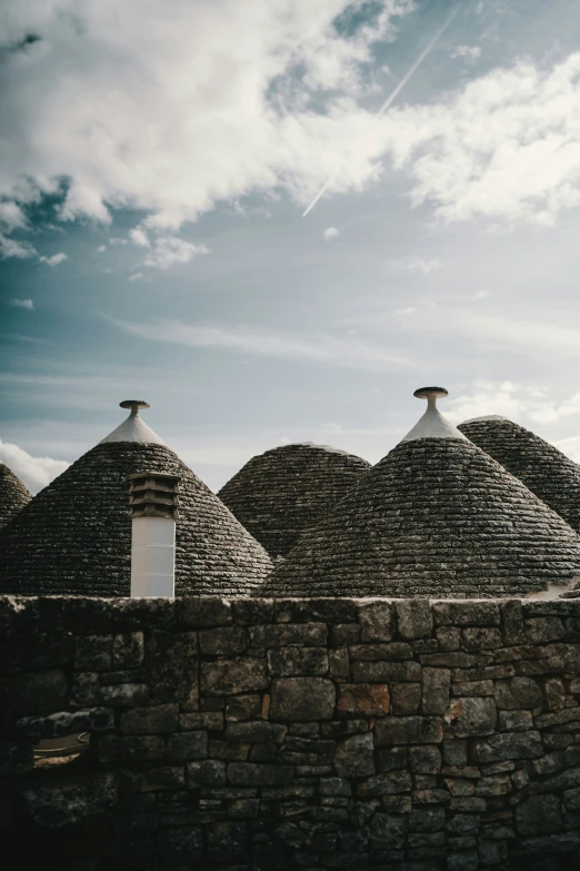 a bunch of stone roofs sit on a cloudy day