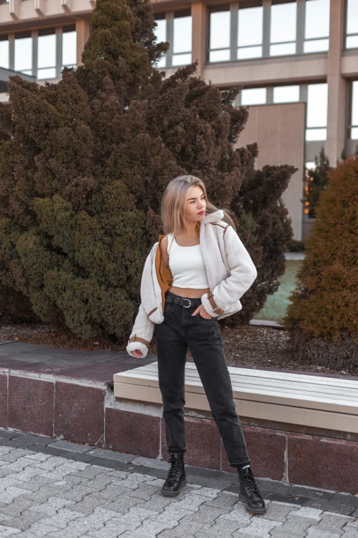 a girl wearing black jeans, white shirt and boots