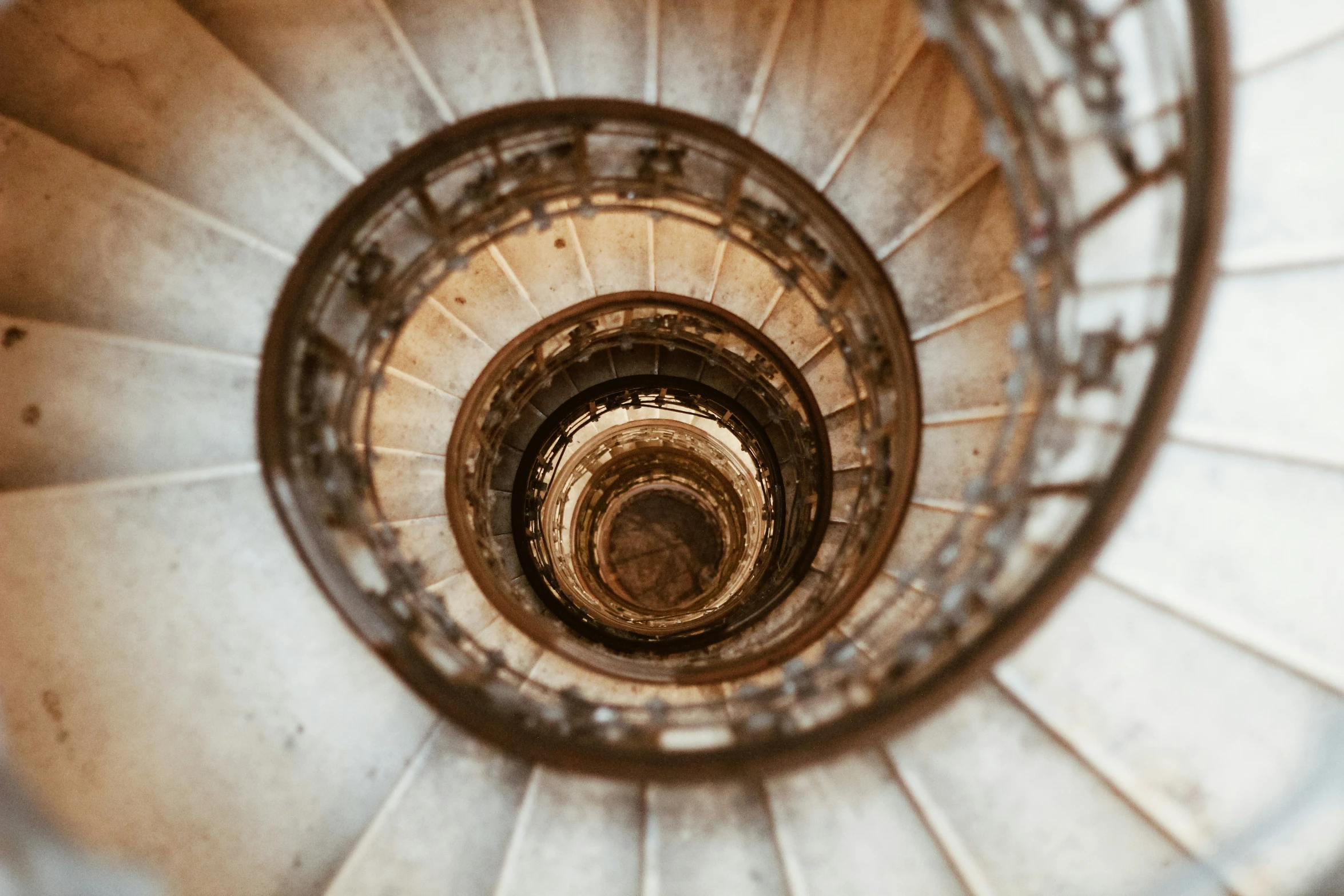 looking down at a spiral stair railing in an architectural building