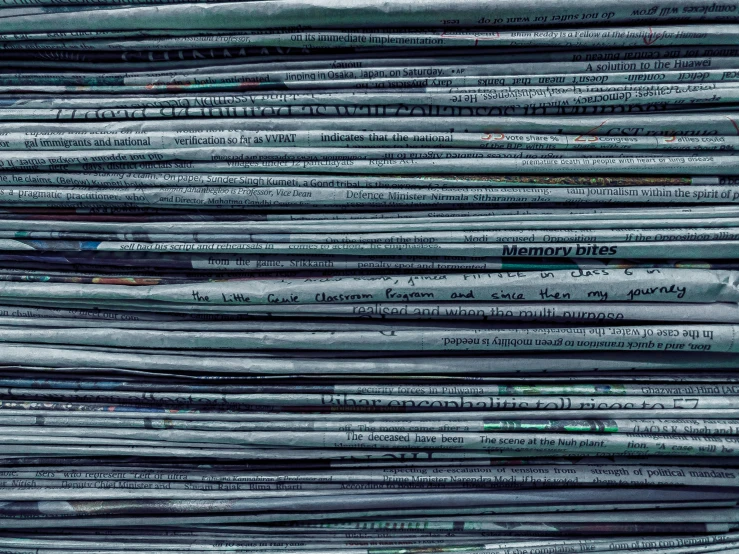 closeup image of many newspapers stacked up