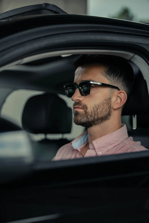 a man in sunglasses is sitting inside a car