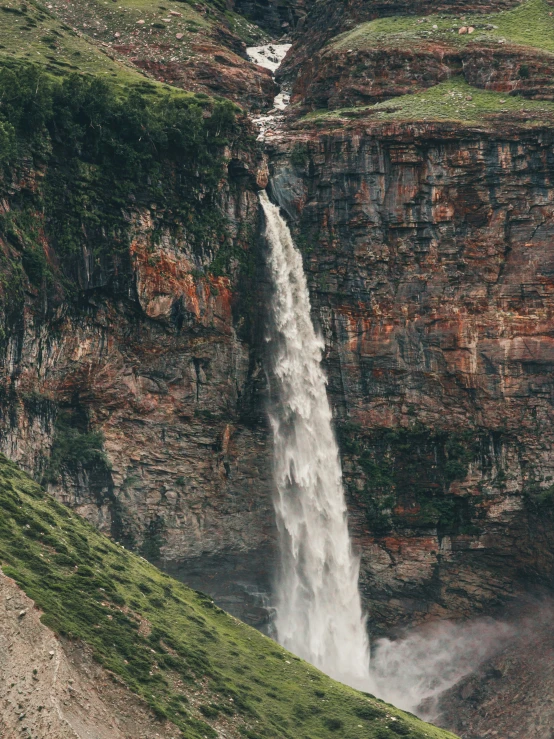 a waterfall with a waterfall running down it's side