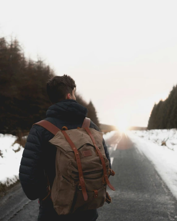 a man with a backpack walking on the snow