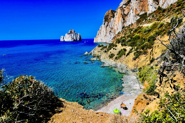 people sitting on the shore looking out at the ocean