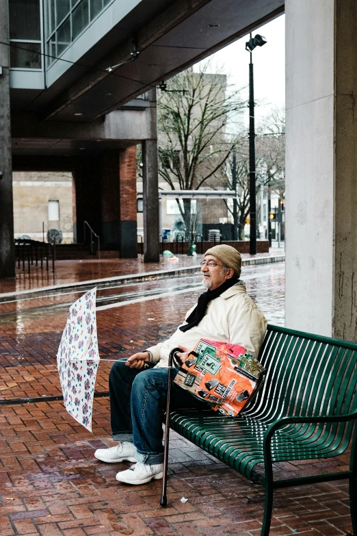 an elderly person sits alone on a bench