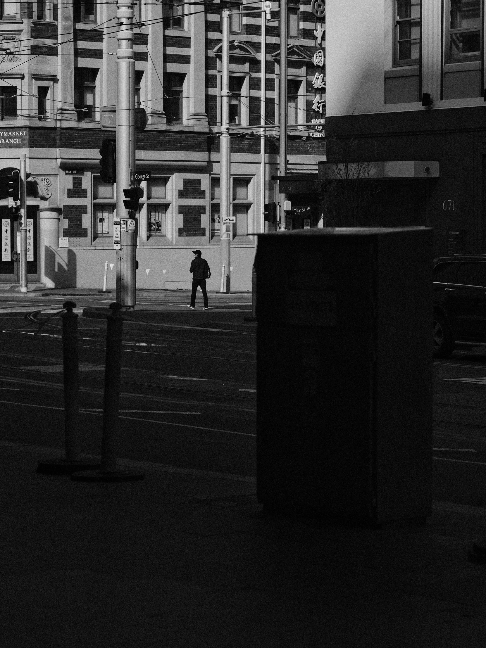 a person walking down a sidewalk in the middle of a city