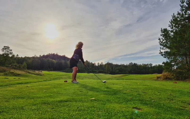 a person on a grass field with the sun behind him