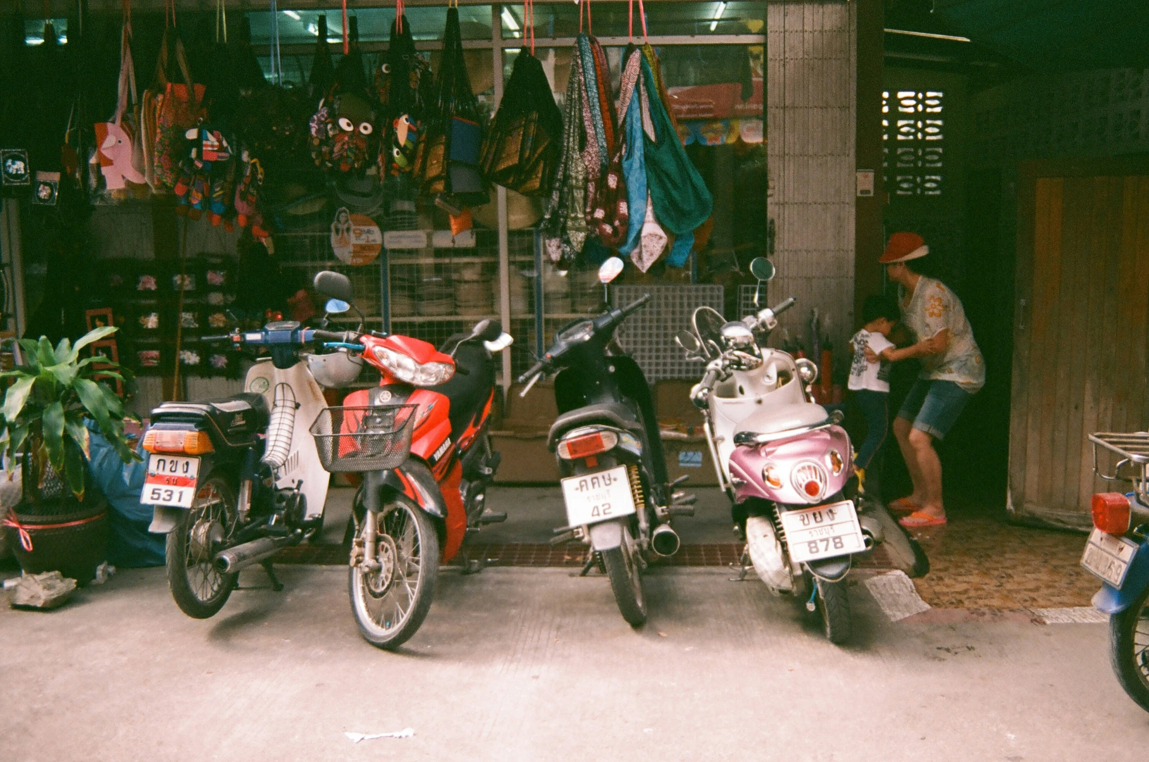 a red motor scooter and a red scooter on a street