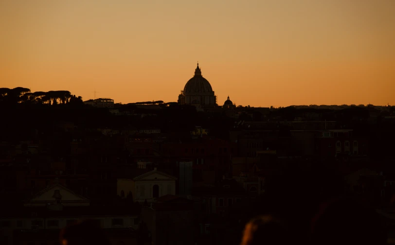 the silhouettes of buildings are shown against the orange sky