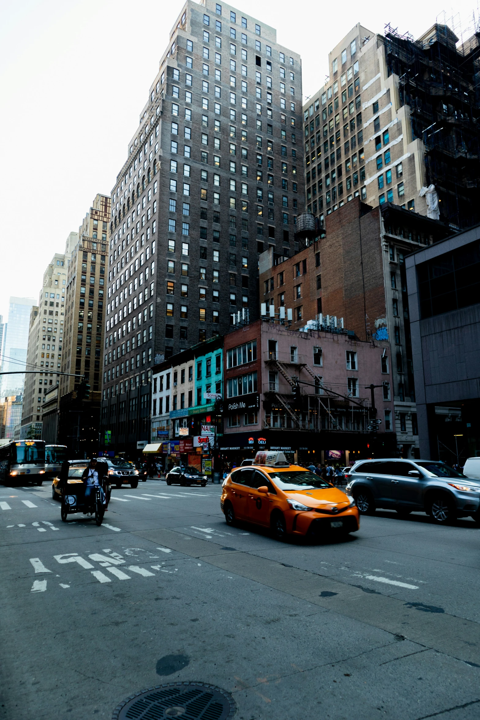 taxi cab driving through busy street with large buildings