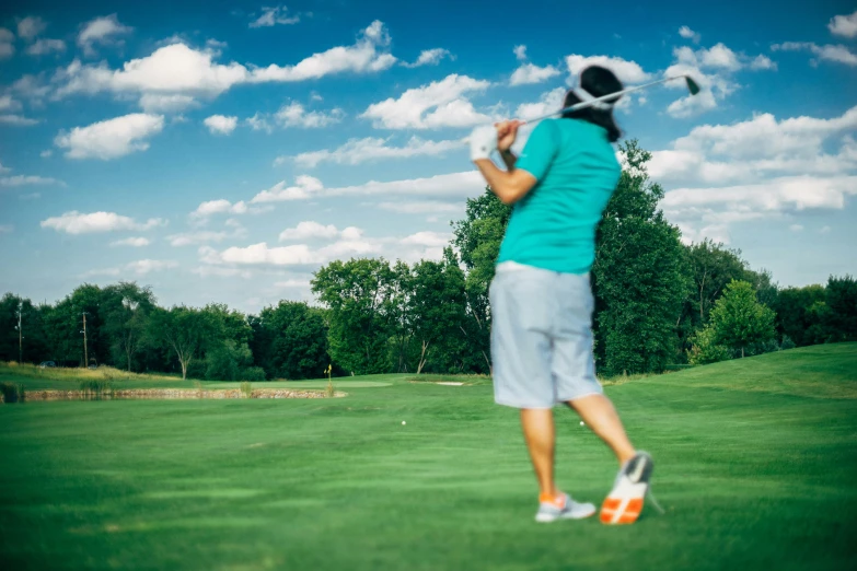 the woman is playing golf in her green outfit