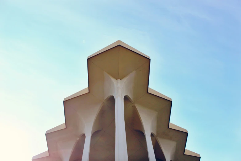 an architectural structure against the sun and a blue sky