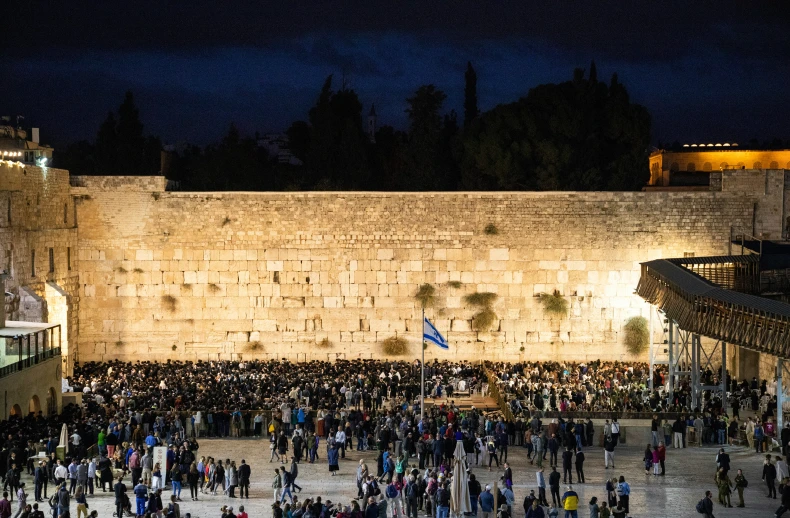 a large crowd is surrounding a wall at night