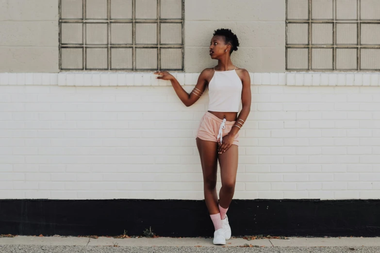 a woman leaning on a brick wall and looking off into the distance