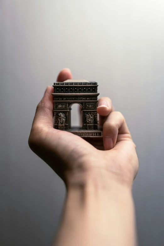 a tiny model of the eiffel tower in the palm