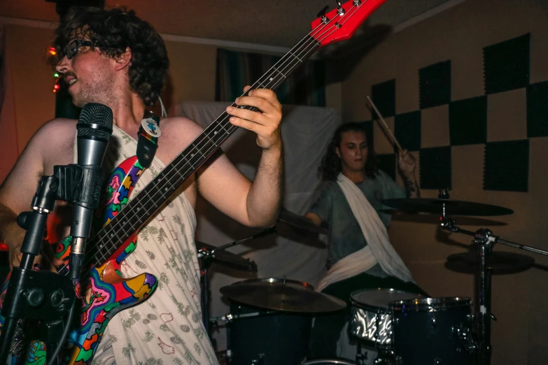 a man holding a guitar in front of a microphone